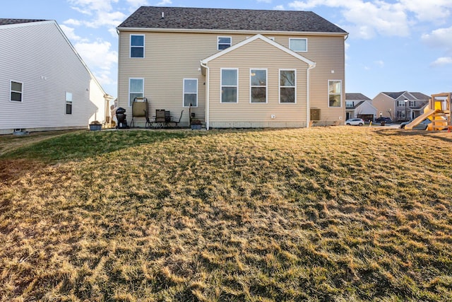 rear view of property with a lawn and a playground