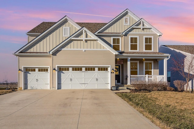 craftsman-style home with board and batten siding, covered porch, an attached garage, and concrete driveway