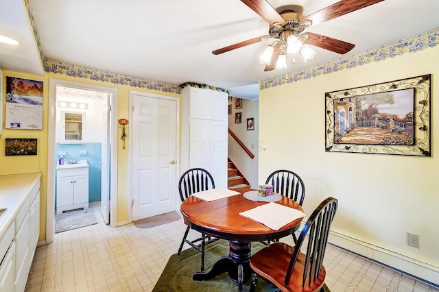 dining space with light floors, ceiling fan, stairway, and baseboard heating