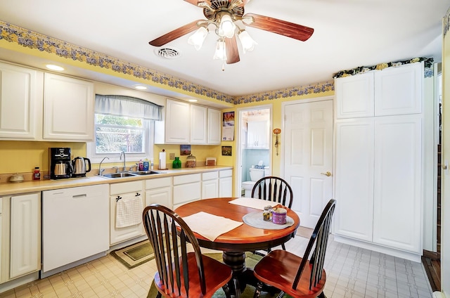 kitchen featuring light floors, light countertops, white cabinets, a sink, and dishwasher