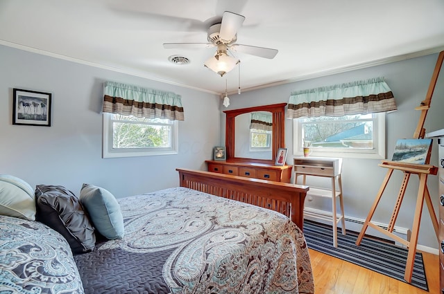 bedroom featuring a ceiling fan, light wood-type flooring, visible vents, and crown molding