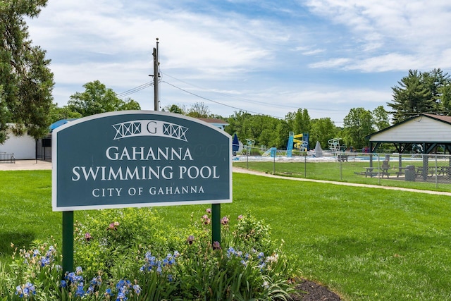 community sign featuring a yard and fence