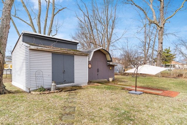 view of barn with a lawn and fence