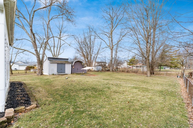 view of yard with fence and an outbuilding