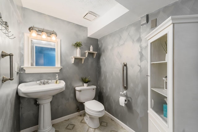 half bathroom with toilet, tile patterned flooring, and baseboards