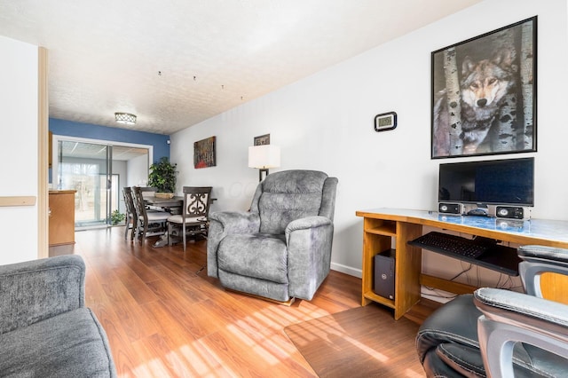 living area featuring baseboards and wood finished floors