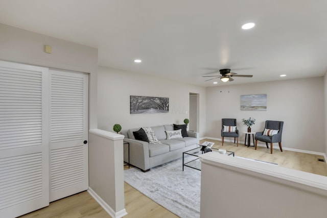 living room with baseboards, ceiling fan, light wood finished floors, and recessed lighting