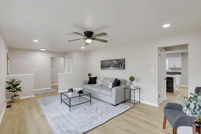 living room with light wood finished floors, baseboards, a ceiling fan, and recessed lighting