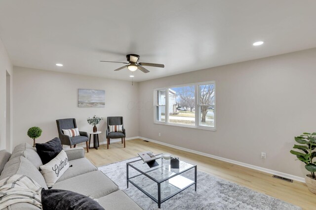 living area with light wood-type flooring, visible vents, baseboards, and recessed lighting