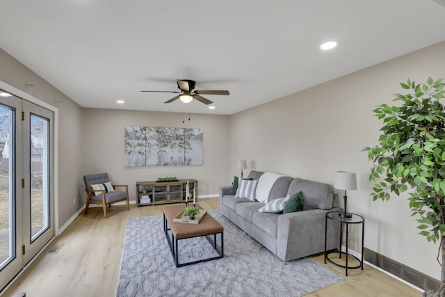 living area with baseboards, recessed lighting, and light wood-style floors