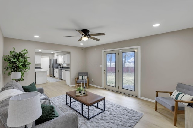 living area with recessed lighting, ceiling fan, light wood finished floors, and baseboards