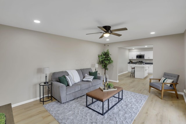 living area featuring light wood finished floors, baseboards, and recessed lighting