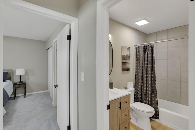 full bath with toilet, shower / bath combo, vanity, ensuite bath, and baseboards