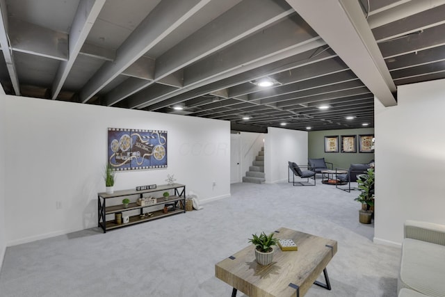 carpeted living area featuring baseboards and stairs