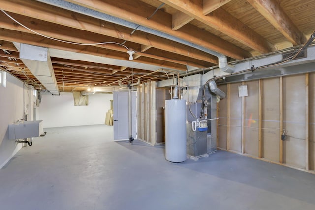 unfinished below grade area featuring gas water heater, a sink, and heating unit