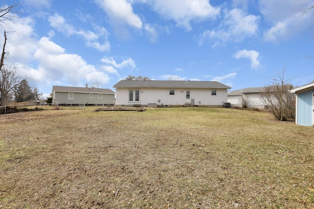 rear view of property featuring a yard and fence