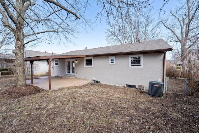 back of property with fence, french doors, a patio area, central AC, and stucco siding