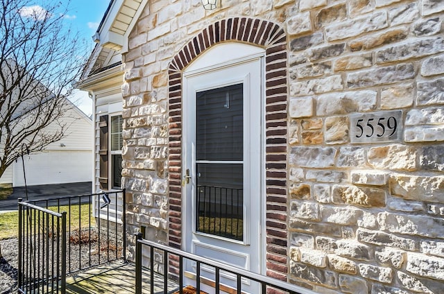 entrance to property with a garage and stone siding