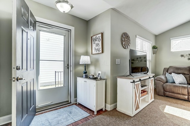 entryway featuring lofted ceiling and baseboards