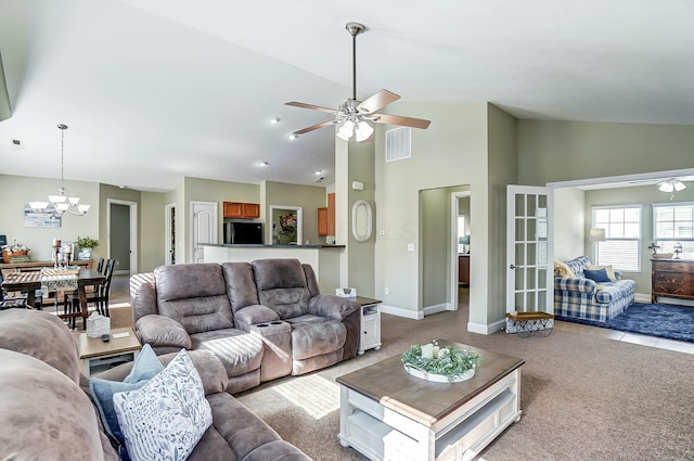 living room featuring light carpet, baseboards, visible vents, and ceiling fan with notable chandelier