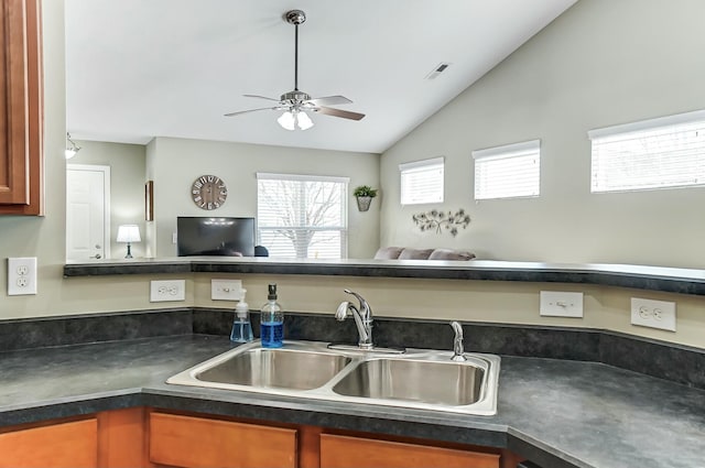 kitchen featuring a sink, visible vents, open floor plan, vaulted ceiling, and dark countertops