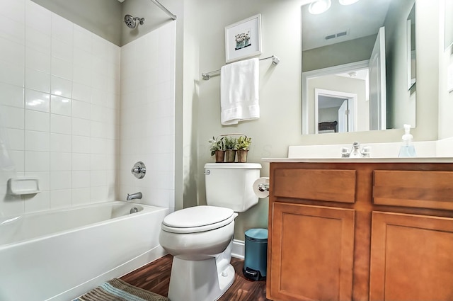 full bath featuring visible vents, shower / bathing tub combination, toilet, vanity, and wood finished floors