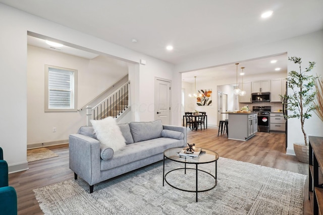 living area featuring light wood-type flooring, baseboards, and recessed lighting