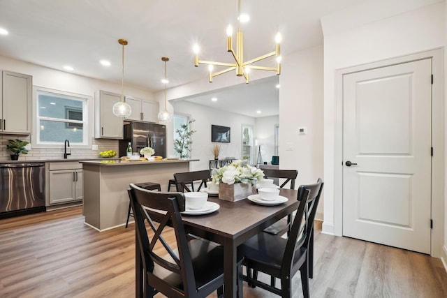 dining room featuring light wood-type flooring, baseboards, and recessed lighting