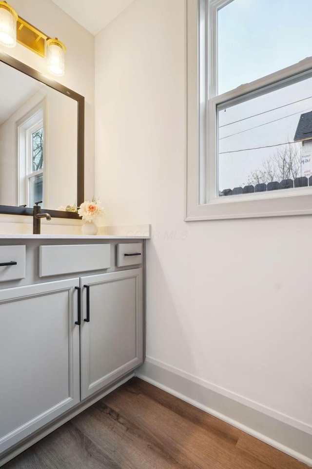 bathroom featuring vanity, baseboards, and wood finished floors