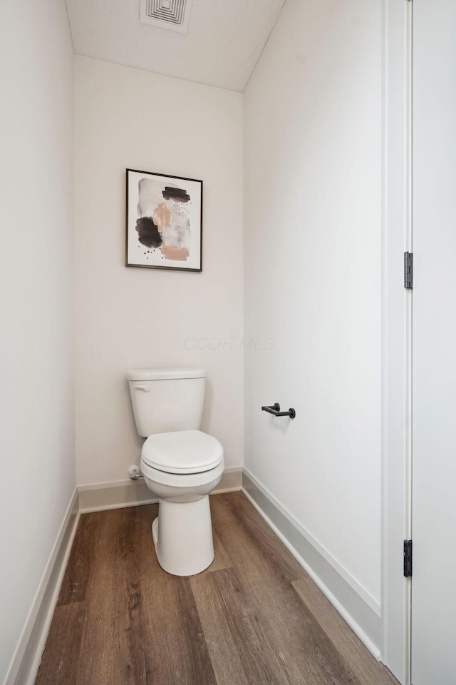 bathroom featuring visible vents, wood finished floors, toilet, and baseboards