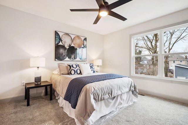 carpeted bedroom with visible vents, baseboards, and a ceiling fan