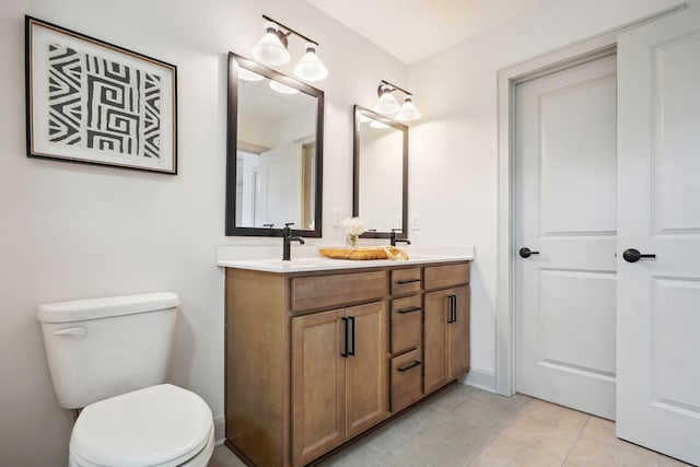 full bathroom with toilet, tile patterned flooring, double vanity, and a sink