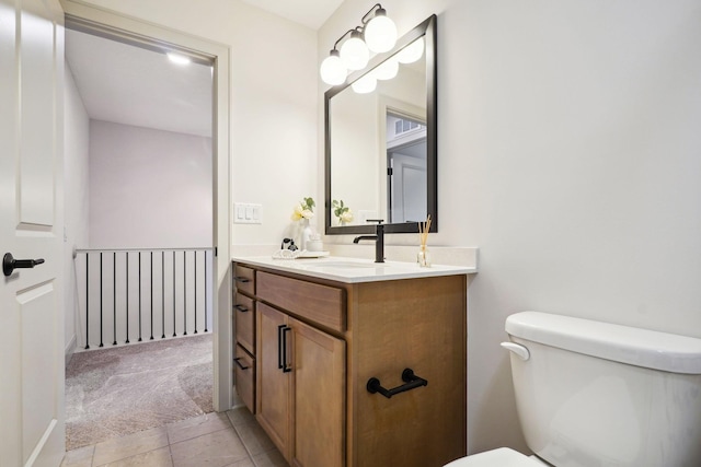 bathroom featuring tile patterned flooring, vanity, and toilet