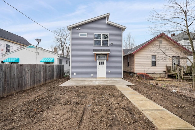 rear view of house with a patio and fence