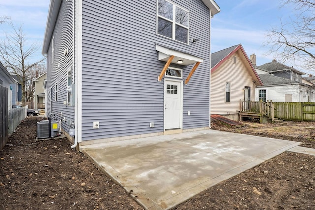 rear view of property featuring a patio, central AC unit, and fence