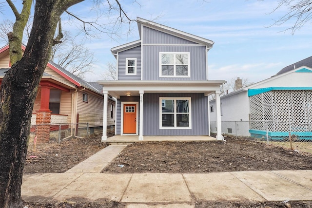 view of front of property with a porch, board and batten siding, and fence