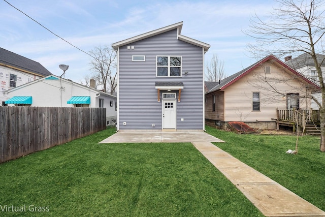 back of property with a patio, a lawn, and fence