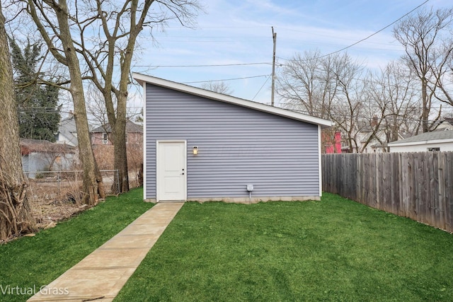 view of outdoor structure featuring a fenced backyard and an outbuilding