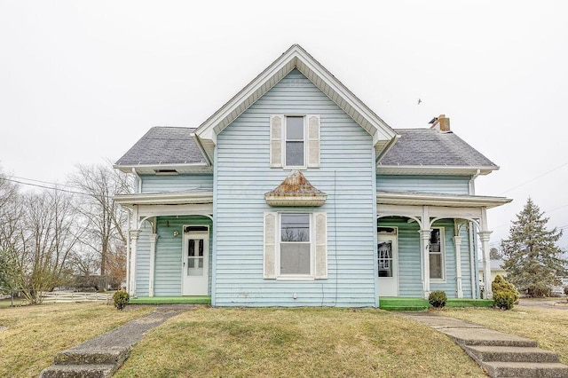 traditional home with a front lawn and a shingled roof