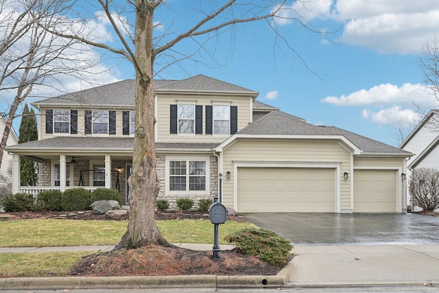 view of front facade with a garage, covered porch, driveway, and a front lawn