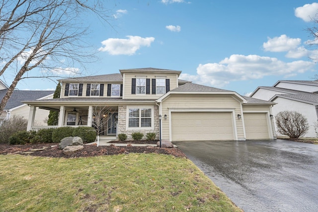 view of front of house featuring a garage, stone siding, aphalt driveway, a front lawn, and a porch