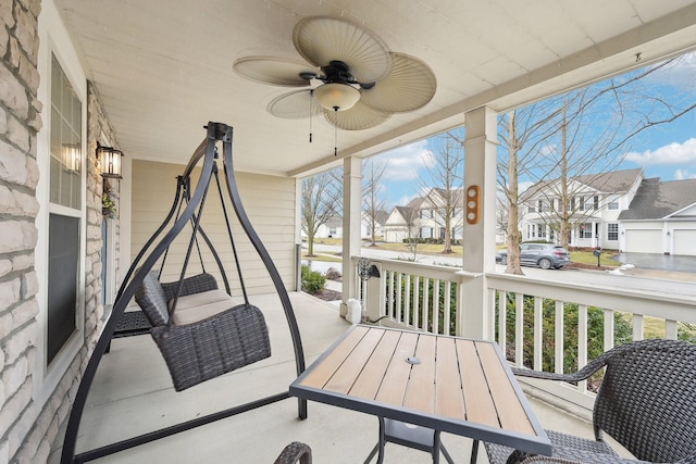 sunroom with ceiling fan and a residential view