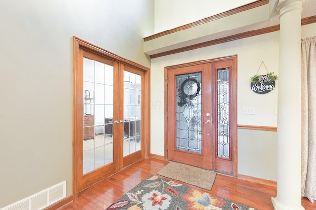 entrance foyer with hardwood / wood-style flooring, visible vents, baseboards, french doors, and decorative columns