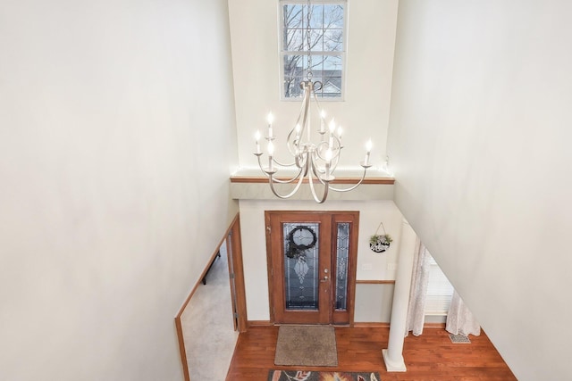 foyer with a notable chandelier and wood finished floors