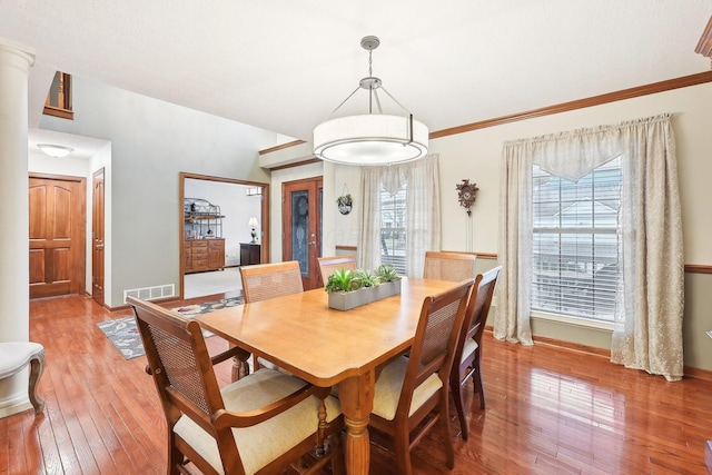 dining space featuring visible vents, ornamental molding, light wood-style flooring, and baseboards