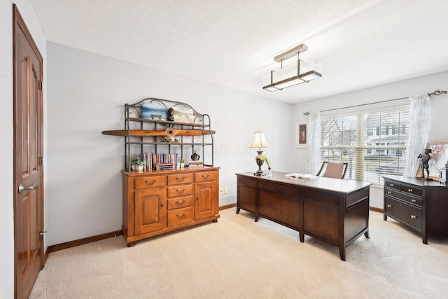 home office with light carpet, a textured ceiling, and baseboards