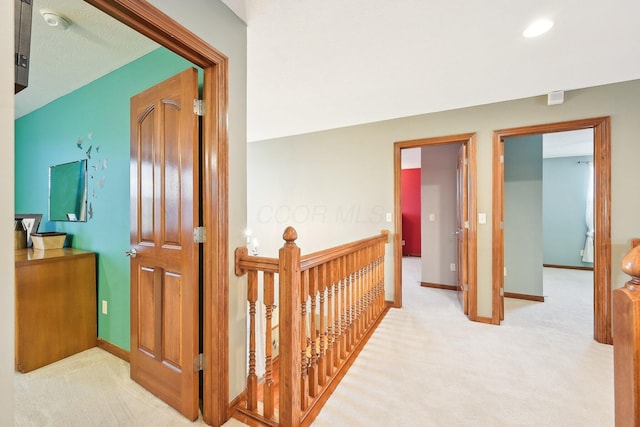 corridor with carpet flooring, an upstairs landing, and baseboards