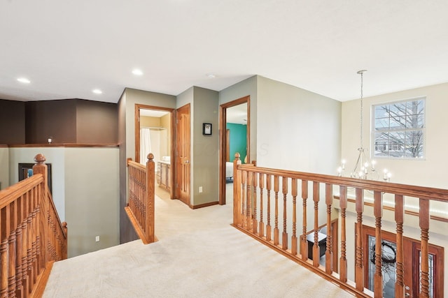 hall featuring a notable chandelier, recessed lighting, an upstairs landing, and light colored carpet