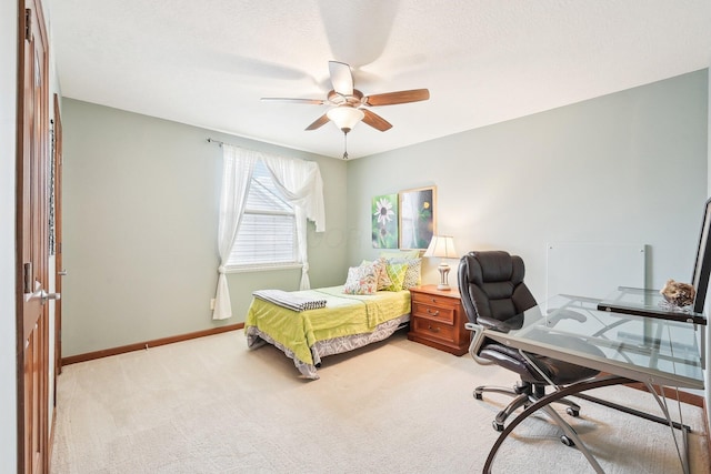 bedroom with a ceiling fan, light carpet, and baseboards