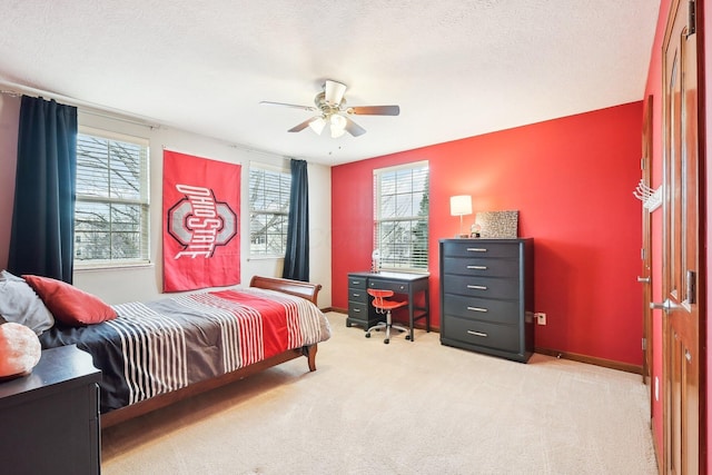 carpeted bedroom with a ceiling fan, multiple windows, a textured ceiling, and baseboards